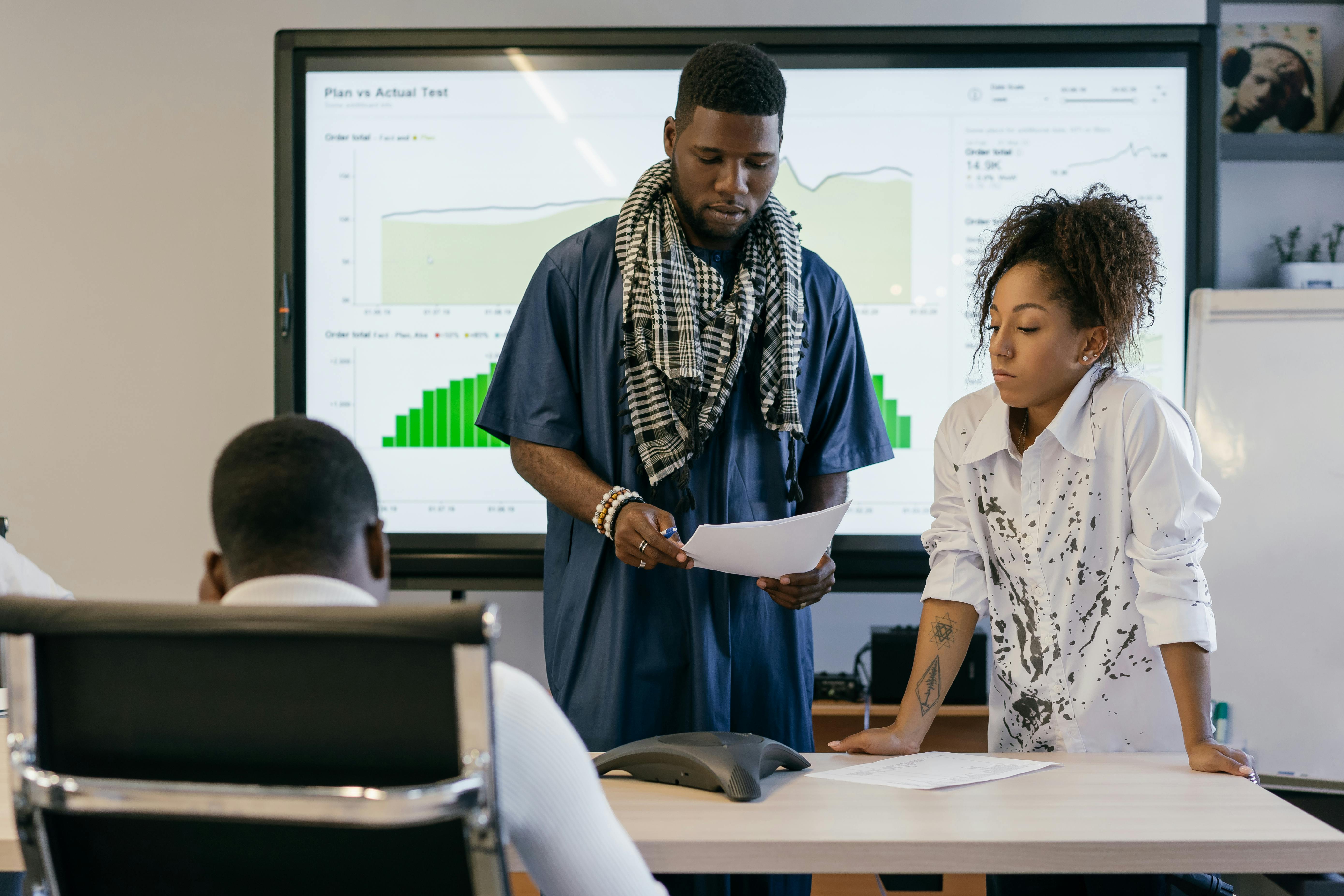 Operational planning session with performance charts on a screen